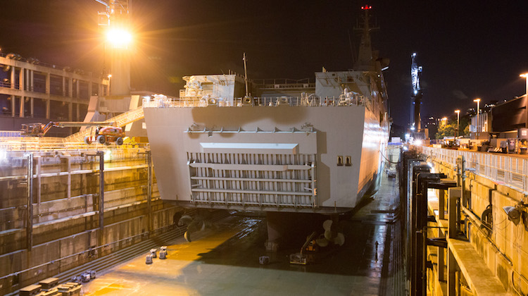 HMAS Adelaide rests on blocks within Captain Cook Graving Dock at Fleet Base East, Sydney, after entering dry dock for maintenance.