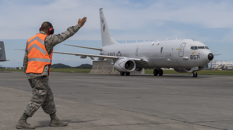 Staff Sgt. Duane Mitchell, 374th Maintenance Squadron transient alert maintenance craftsman, guides a navy P-8A Poseidon aircraft into parking spot, Sept. 15, 2017, at Yokota Air Base, Japan. The Navy P-8A Poseidon came to Yokota as a static display for the Japanese-American Friendship Festival. (U.S. Air Force photo by Airman 1st Class Donald Hudson)