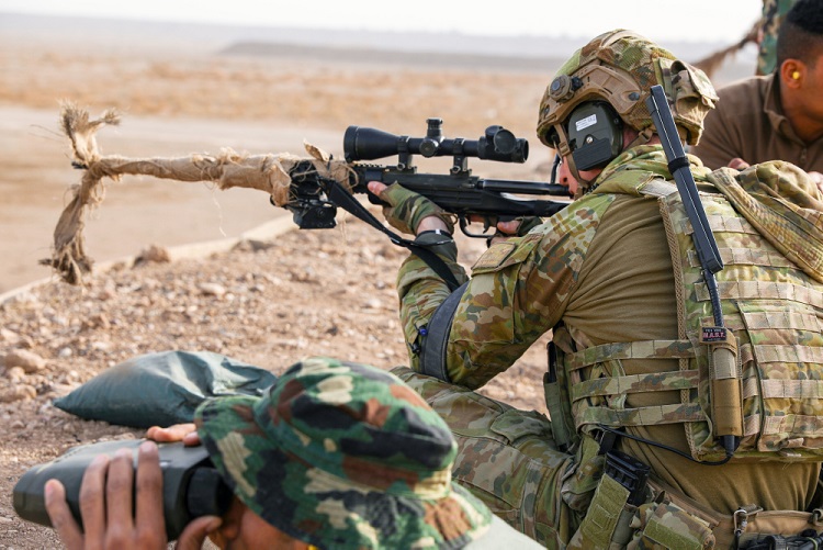 An Australian Army trainer demonstrates a good seated firing position with a M40 bolt-action sniper rifle for an Iraqi security forces member, in preparation for the qualification portion of an advanced marksman course at Camp Taji, Iraq, Jan. 24, 2018. Camp Taji is one of four Combined Joint Task Force  Operation Inherent Resolve building capacity locations dedicated to training partner forces and enhancing their effectiveness on the battlefield. (U.S. Army photo by Spc. Audrey Ward)