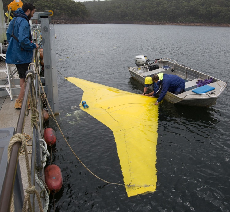 Alan Lavery from the Ron Allum Deepsea Services, prepares to launch the Sun Ray Glider at Woronora Dam, Sydney. *** Local Caption *** The Sun Ray Glider unmanned undersea flying wing was put through a series of underwater tests at Woronora Dam southwest of Sydney. The glider contains an internal buoyancy vessel that can be flooded or pumped out to change the vehicle's displacement, making it sink or rise. The resulting movement of water over the wing's surface generates forward thrust, removing the need for propeller or waterjet propulsion. It is built partly of syntactic composite foam that holds its shape even at extreme pressures, giving the glider greater depth capability than manned submarines. It may allow missions of up to three months, gliding more than 2,000 nautical miles.