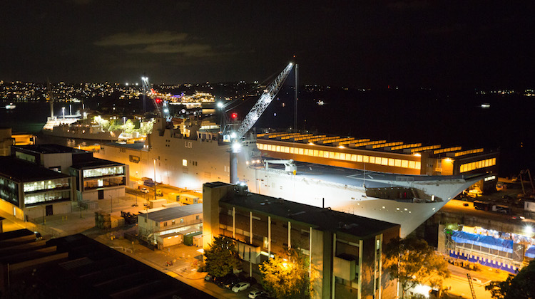 HMAS Adelaide rests on blocks within Captain Cook Graving Dock at Fleet Base East, Sydney, after entering dry dock for maintenance.