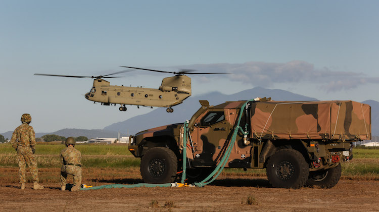 Australian Army CH-47F Chinook hovers into position while conducting external lift trials with the Hawkei Protected Mobility Vehicle.